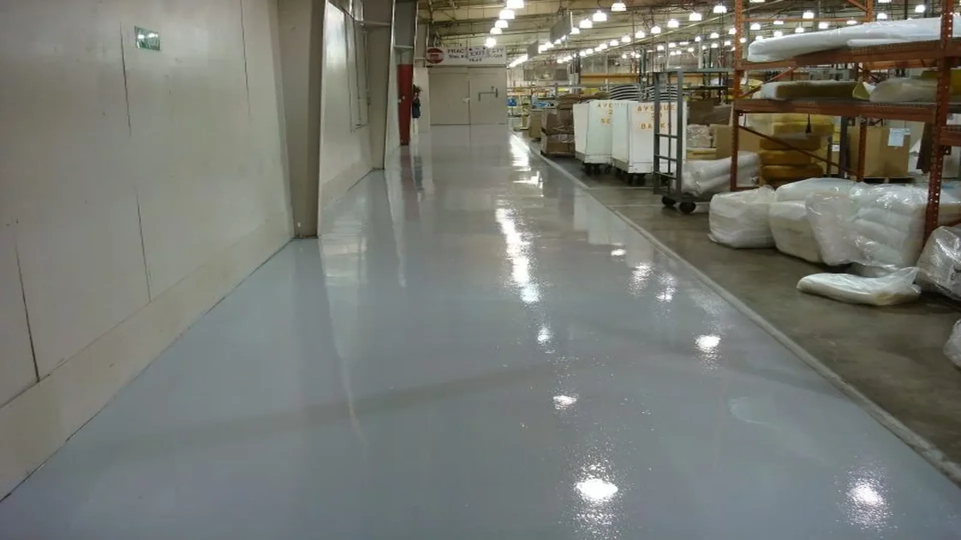Resinous epoxy flooring in a warehouse corridor with a high-gloss diamond topcoat finish by TVS Coatings in Idaho.