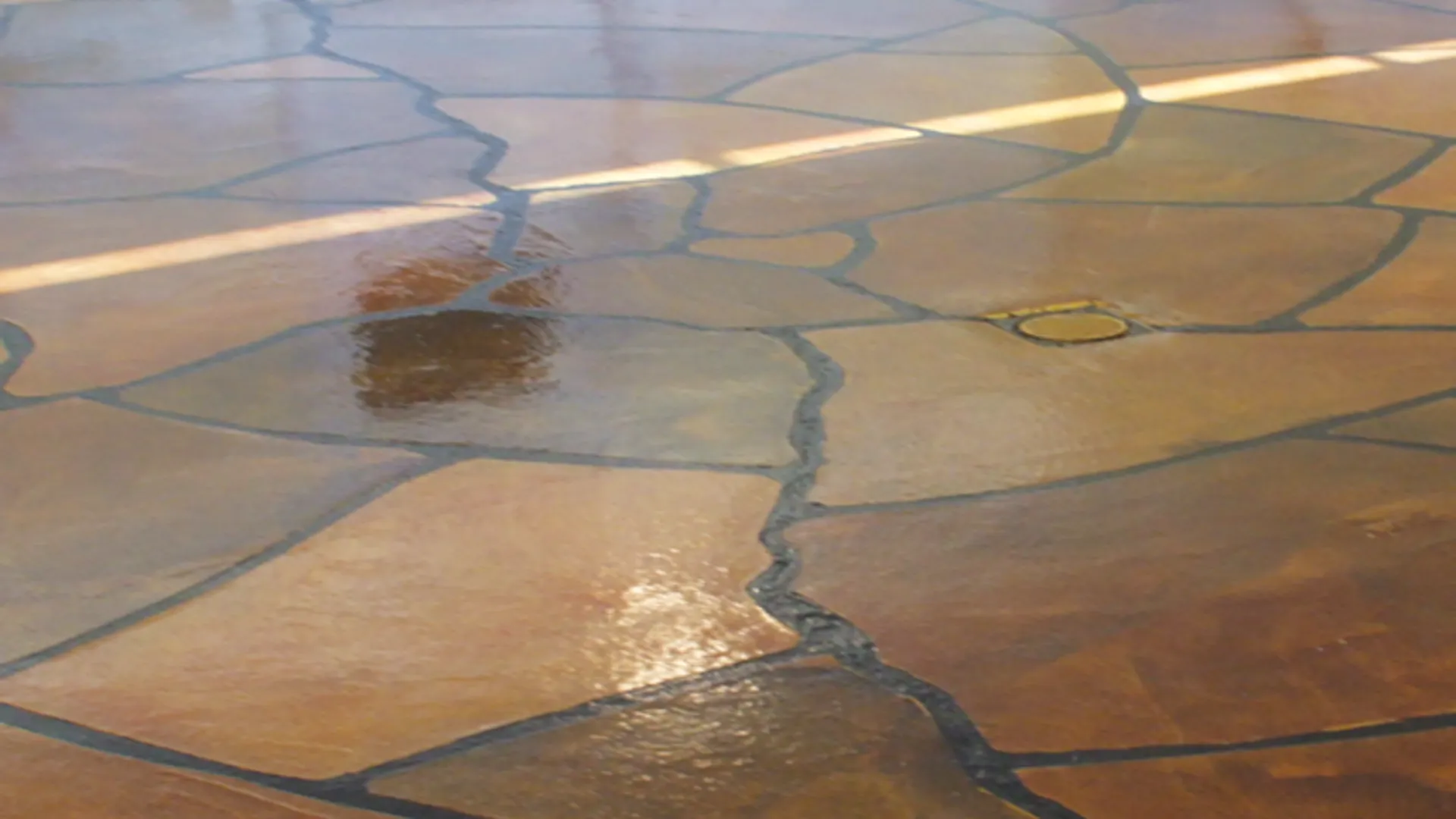 Decorative epoxy concrete flooring in a garage with grand flagstone pattern in Idaho by TVS Coatings.