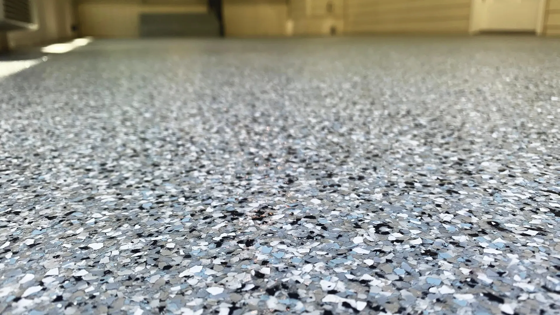 Graniflex floor coating system with decorative flake finish, offering flexible, slip-resistant, and weatherproof protection for concrete surfaces.