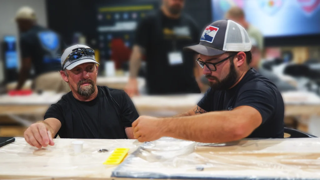 Jim Lasson and partner working on epoxy flooring during a decorative concrete training session.